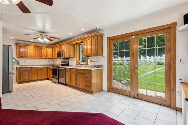 a large kitchen with stainless steel appliances granite countertop a sink and cabinets