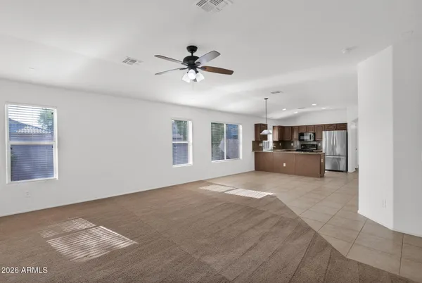 a big room with chandelier fan and windows