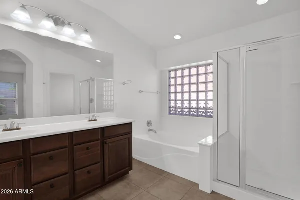 a spacious bathroom with a double vanity sink mirror and bathtub