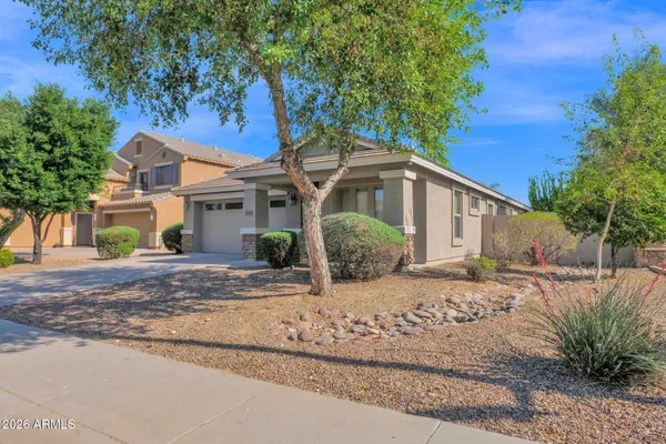 a front view of a house with yard and trees