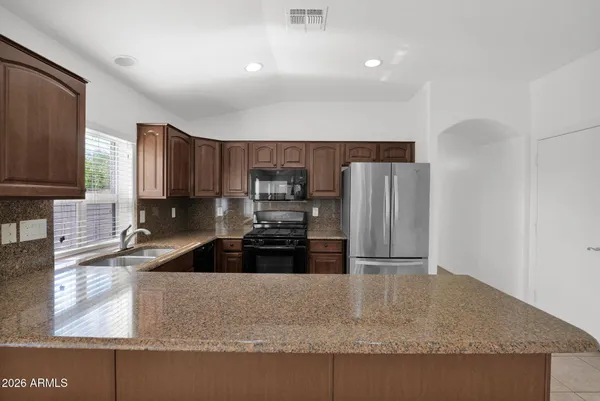 a kitchen with granite countertop a refrigerator and a sink