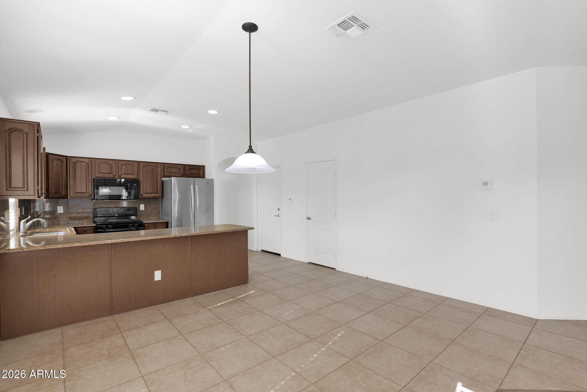 2730 East Dry Wood Road Phoenix, AZ 85024 - Photo 8 of 33 a kitchen with stainless steel appliances a sink a counter top space cabinets and a view of living room