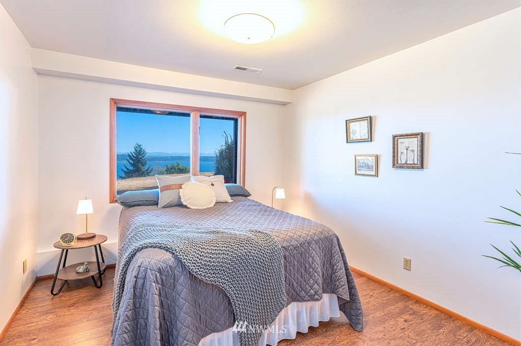 19038 Ridge Road Southwest Vashon, WA 98070 - Photo 24 of 38 a bed sitting in a bedroom next to a window with chair and table
