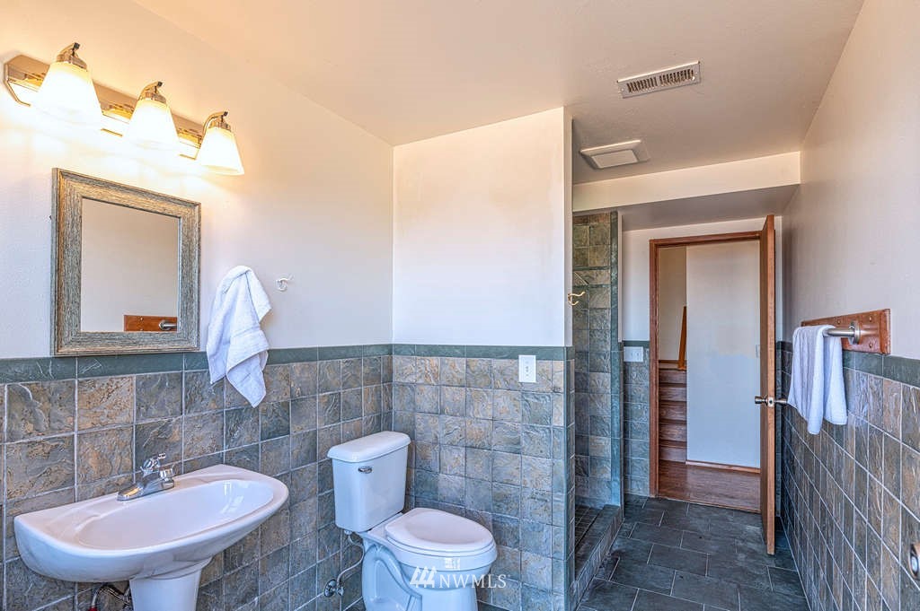 19038 Ridge Road Southwest Vashon, WA 98070 - Photo 25 of 38 a bathroom with a toilet a sink and mirror