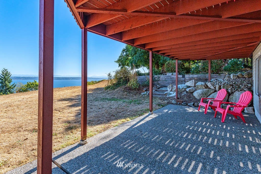 19038 Ridge Road Southwest Vashon, WA 98070 - Photo 30 of 38 a view of a patio with table and chairs under an umbrella