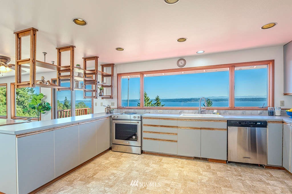 19038 Ridge Road Southwest Vashon, WA 98070 - Photo 7 of 38 a view of a kitchen with kitchen island a window a sink and cabinets
