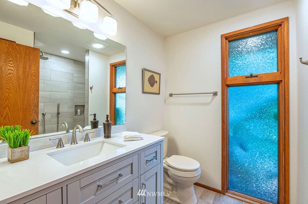 19038 Ridge Road Southwest Vashon, WA 98070 - Photo 10 of 38 a bathroom with a granite countertop sink toilet and a mirror