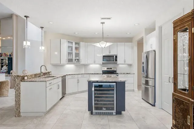 a kitchen with stainless steel appliances granite countertop a refrigerator and a sink