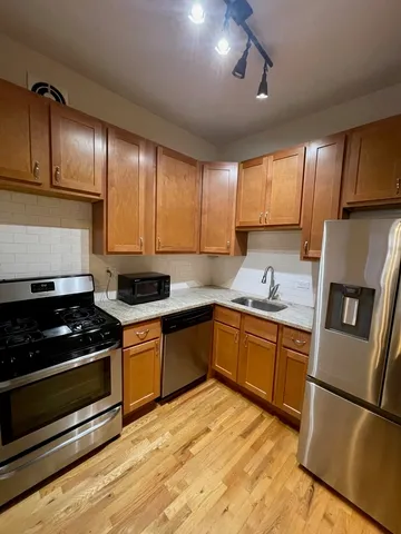 a kitchen with granite countertop stainless steel appliances and wooden cabinets