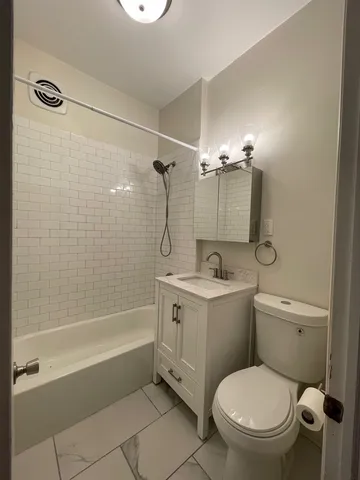 a bathroom with a granite countertop toilet a sink and bathtub