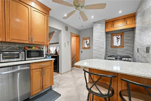 a kitchen with stainless steel appliances granite countertop a kitchen island a stove a sink dishwasher and cabinets with wooden floor