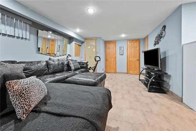 a living room with furniture a flat screen tv and a window