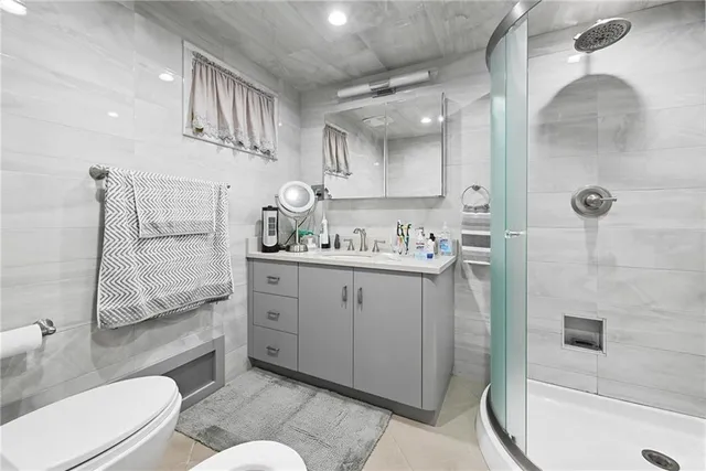 a bathroom with a granite countertop sink mirror vanity shower and toilet