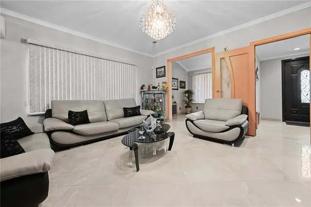 a living room with furniture and a chandelier