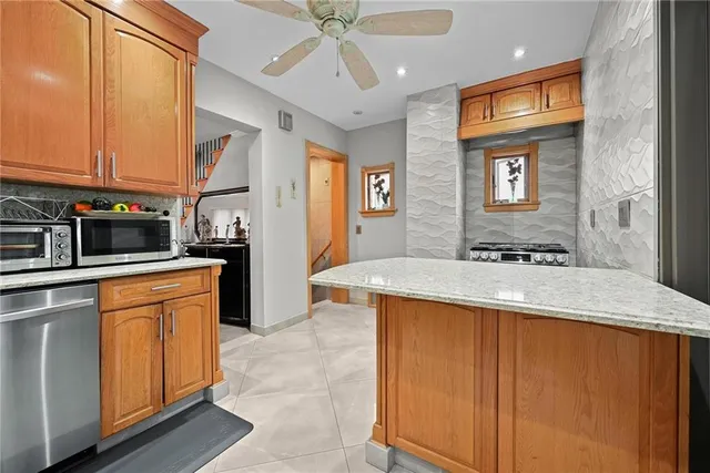 a kitchen with stainless steel appliances granite countertop a sink stove and refrigerator
