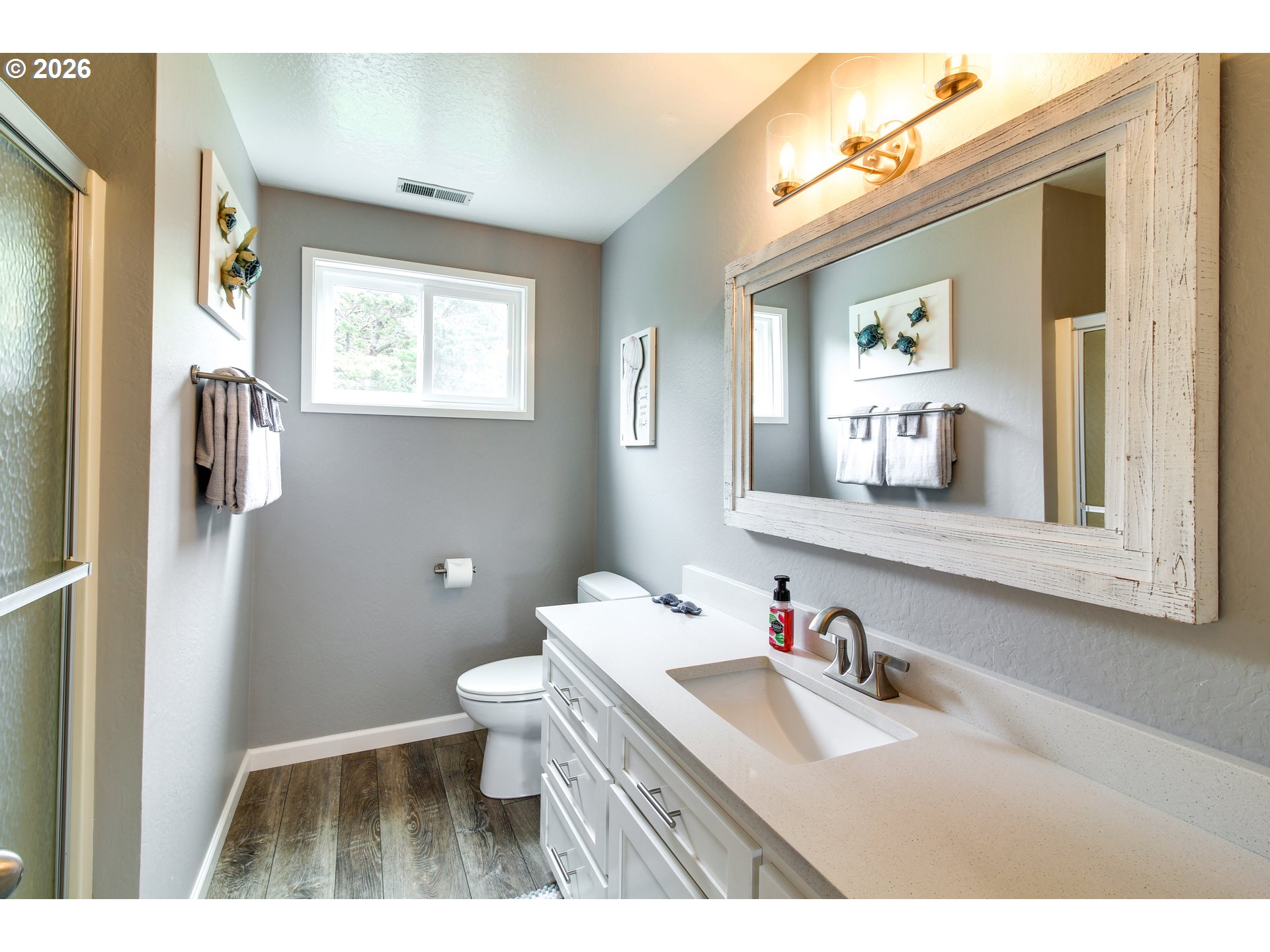 3085 Beach Loop Drive Southwest Bandon, OR 97411 - Photo 26 of 46 a bathroom with a granite countertop sink toilet and a mirror