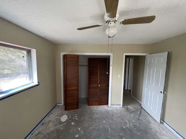 an empty room with fan and windows