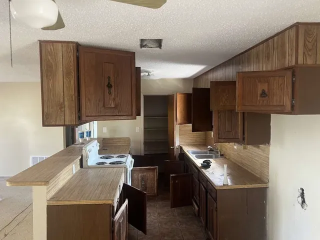 a kitchen with a sink a stove and cabinets