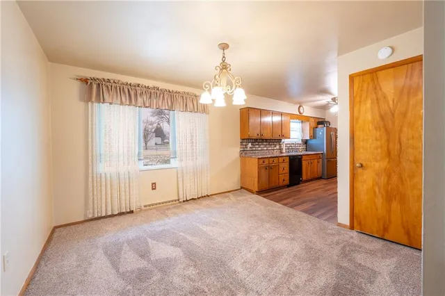 a view of a kitchen with refrigerator and cabinets