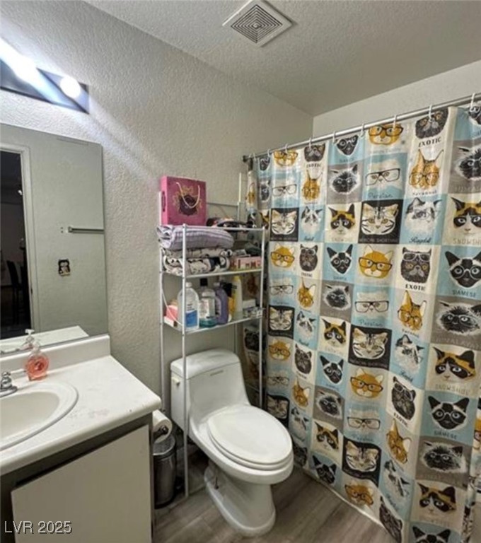 221 Mission Newport Lane, Unit 205 Las Vegas, NV 89107 - Photo 11 of 11 Bathroom with a textured wall, dark wood finished floors, vanity, a shower with shower curtain, and a textured ceiling