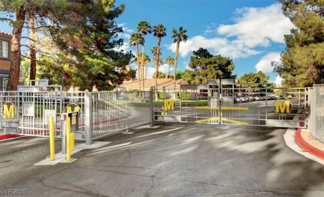221 Mission Newport Lane, Unit 205 Las Vegas, NV 89107 - Photo 6 of 11 View of asphalt road with a gate, a gated entry, and curbs