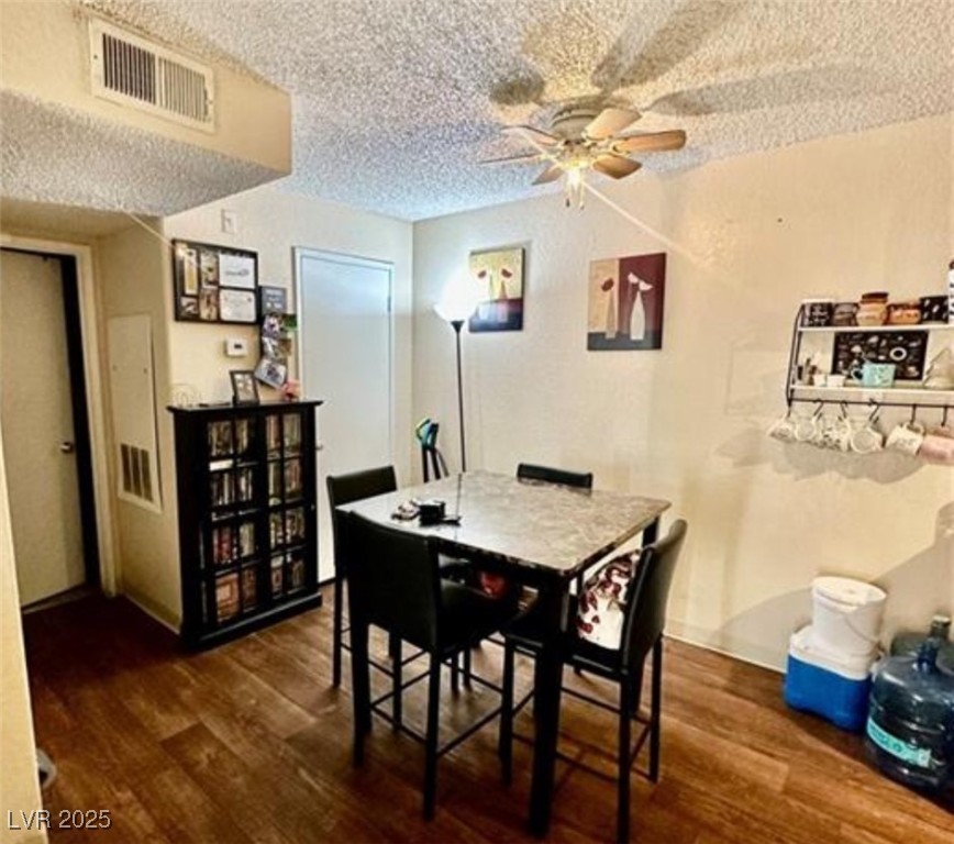 221 Mission Newport Lane, Unit 205 Las Vegas, NV 89107 - Photo 9 of 11 Dining room with dark wood-type flooring, a ceiling fan, and a textured ceiling