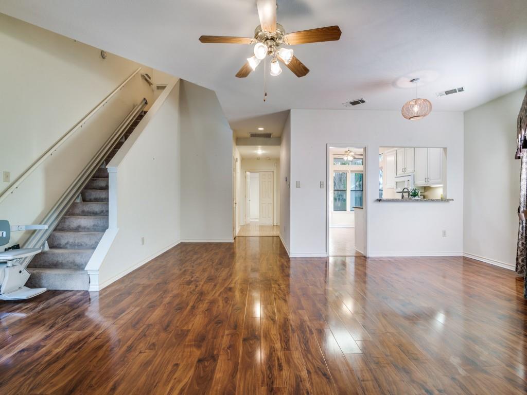 9981 Waterfront Trail Rowlett, TX 75087 - Photo 6 of 26 Unfurnished living room with ceiling fan, dark wood-style flooring, and stairway