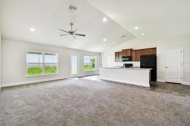 a large kitchen with kitchen island granite countertop a large counter top stainless steel appliances and cabinets