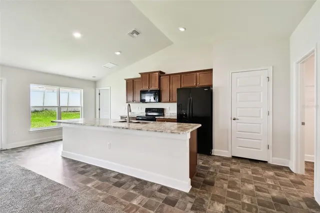 a kitchen with granite countertop cabinets stove and microwave