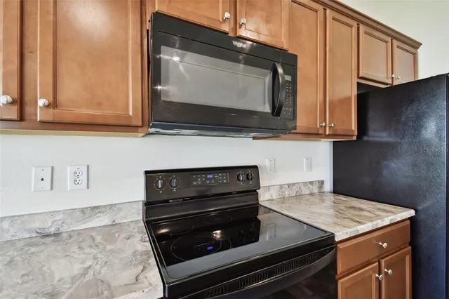 a kitchen with stainless steel appliances granite countertop a stove a sink and a refrigerator