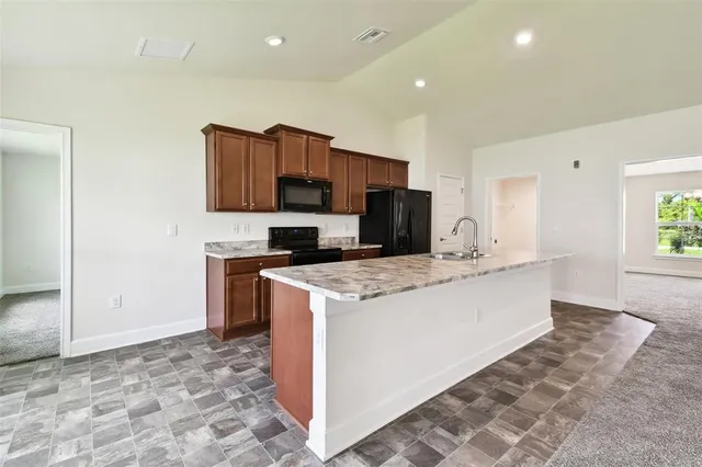 a kitchen with stainless steel appliances granite countertop a refrigerator and a sink