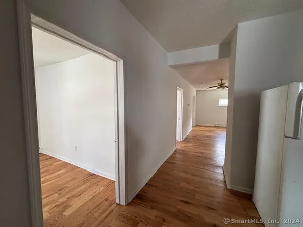 a view of a hallway with wooden floor