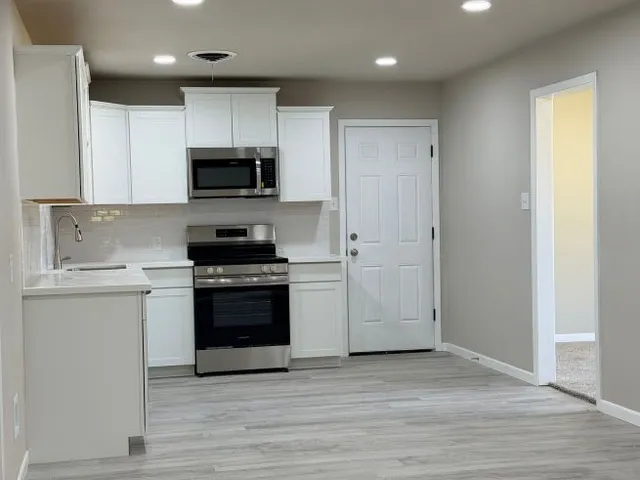 a kitchen with a sink stove and microwave