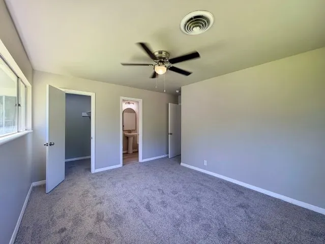 a view of a livingroom with a ceiling fan and window