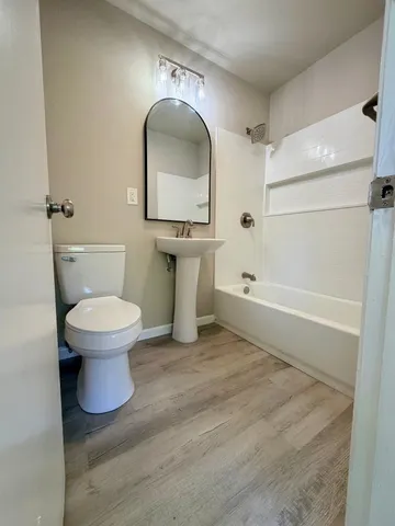 a bathroom with a toilet sink and mirror