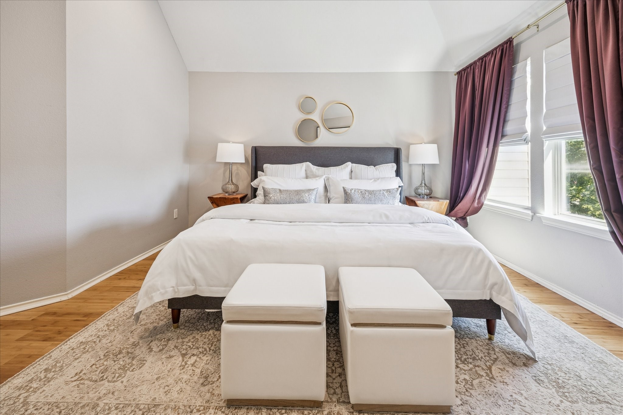 2607 Link Road Houston, TX 77009 - Photo 16 of 21 This bedroom features a spacious layout with a comfortable bed framed by elegant nightstands and lamps. Soft, inviting colors and natural light from large windows with stylish drapery enhance the serene ambiance. A cozy rug and decorative wall accents add a touch of sophistication.