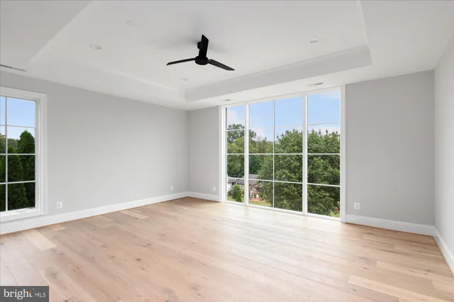 an empty room with a window and a ceiling fan