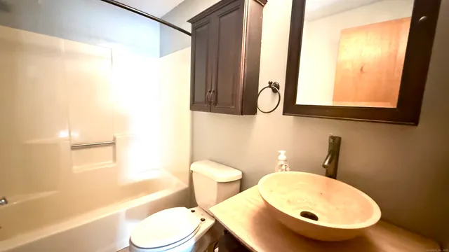 a bathroom with a toilet a sink and a mirror