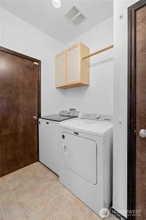 a utility room with cabinets washer and dryer