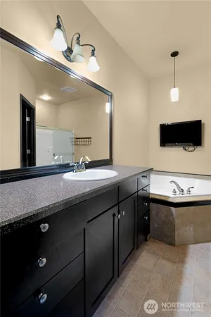 a bathroom with a granite countertop sink a large mirror and a bathtub