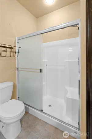 a bathroom with a shower a toilet and a window