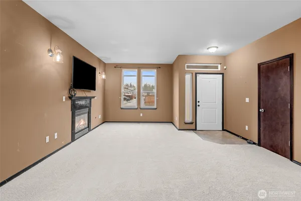 an empty room with windows and flat screen tv