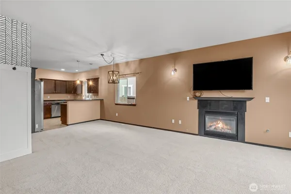a view of a livingroom with a fireplace a flat screen tv and staircase