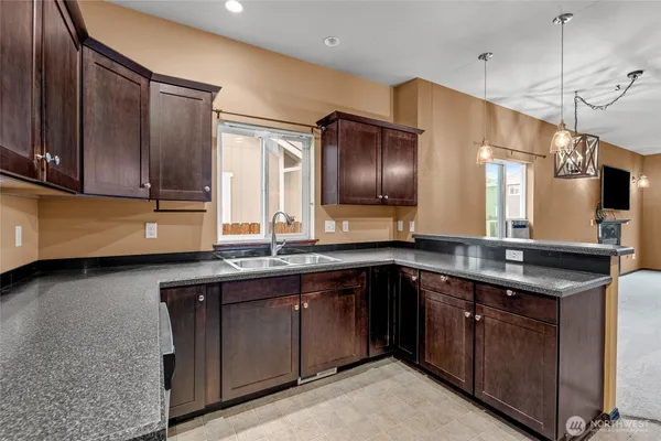 a kitchen with stainless steel appliances granite countertop a sink a stove and a refrigerator