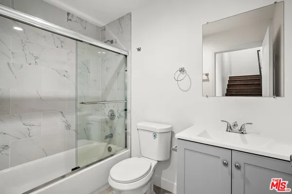 a bathroom with a toilet sink shower and mirror