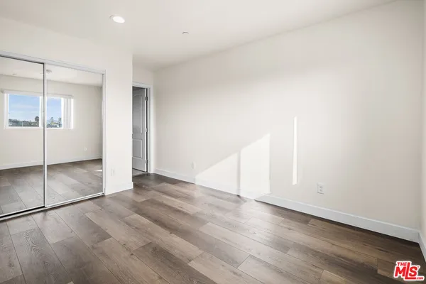 an empty room with wooden floor and white walls