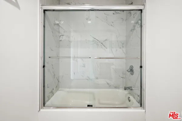 a white bath tub sitting next to a white sink and vanity