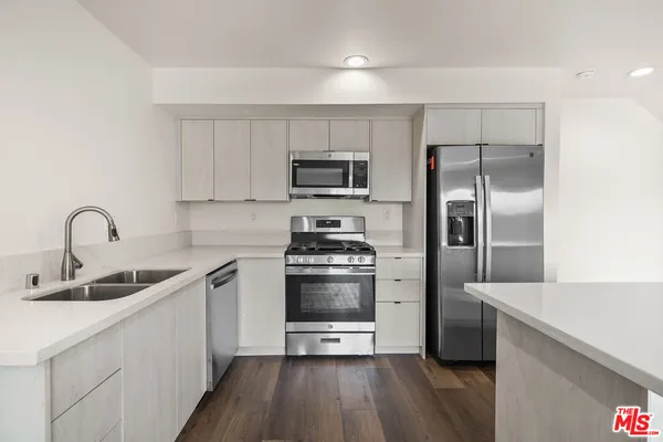 a kitchen with kitchen island a sink and stainless steel appliances