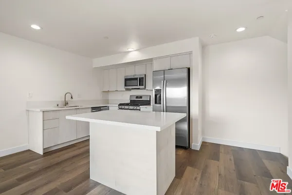 a kitchen with stainless steel appliances a sink stove and refrigerator