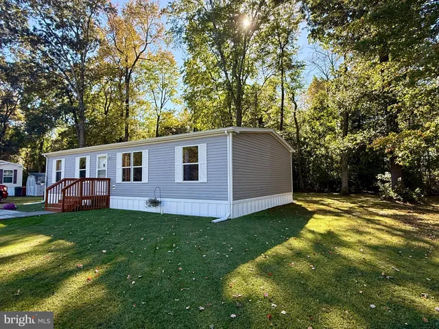 a view of a yard in front of a house with large trees